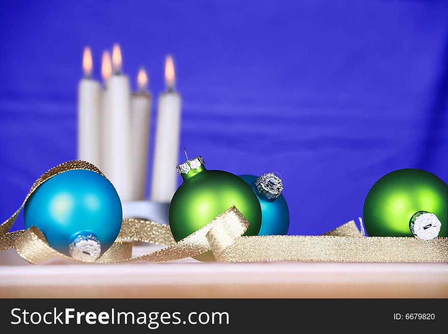 Blue and green ornaments with candles and blue background