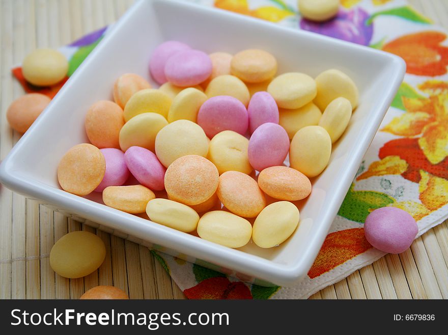 Some colourful candies in a white bowl