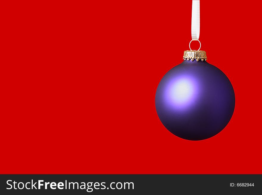 Purple christmas ornament on red background