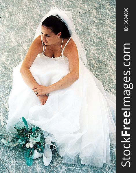 A bride stiing on tiles gazing dreamily. A bride stiing on tiles gazing dreamily.