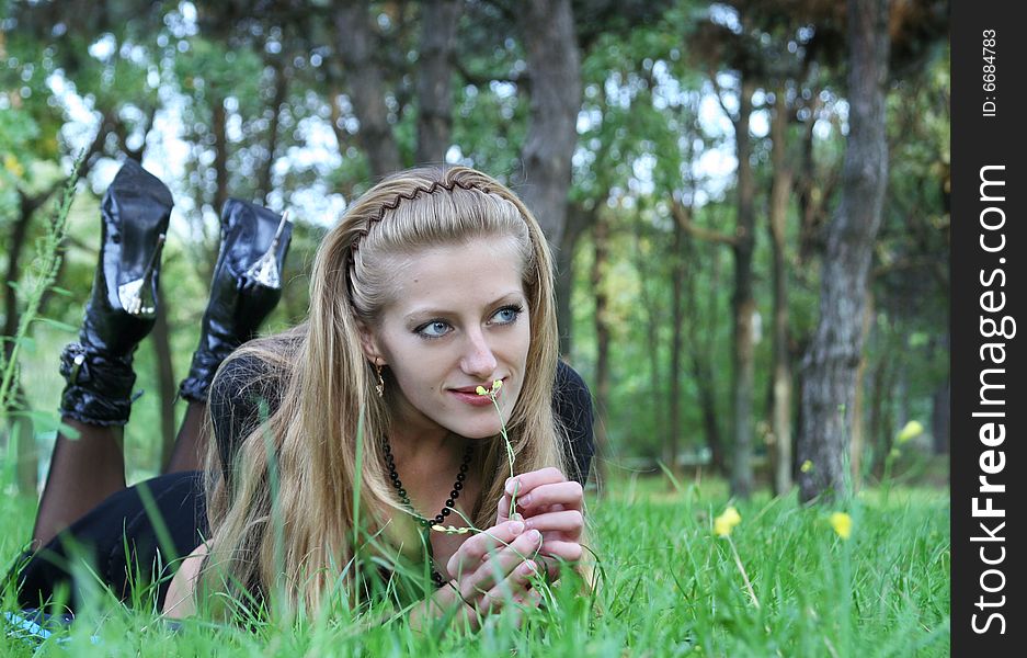 The younger girl reposes in the park. The younger girl reposes in the park