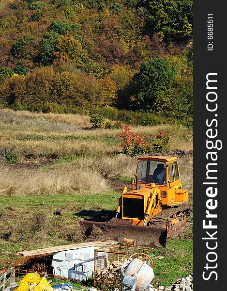 Yellow backhoe loader on construction site