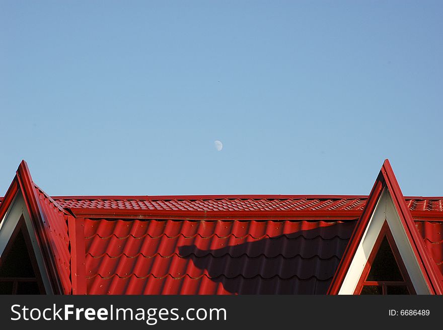 Moone over red roof in evening. Moone over red roof in evening