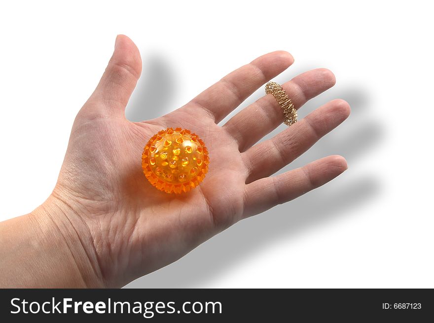 Hand with a ball for massage of orange color.