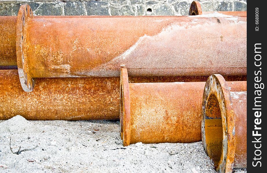 Rusty industrial water pipes on the beach corroded in sea water