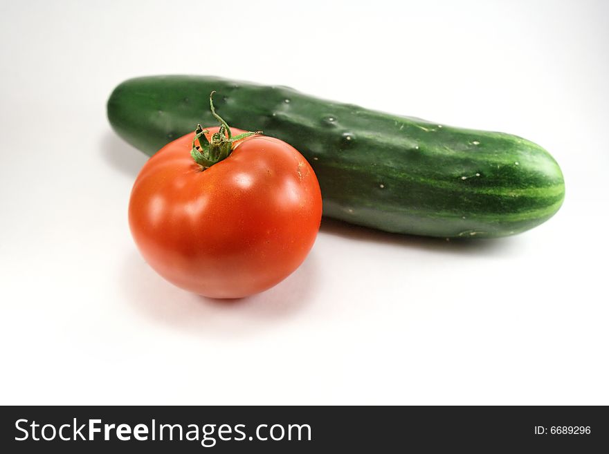 Fresh tomato and cucumber against white background