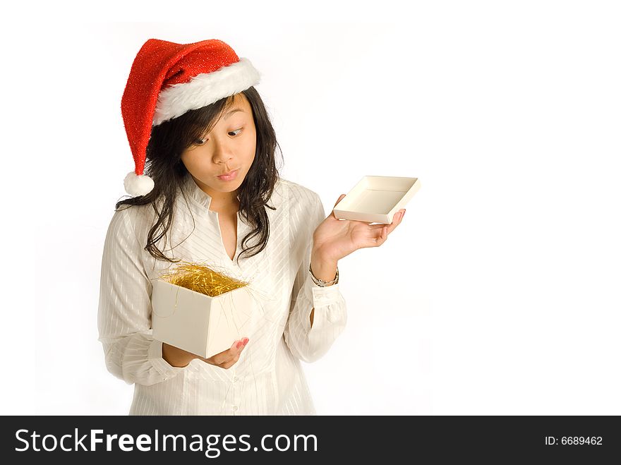 Teenager Asian girl in Santa Claus hat opening a gift box at a Christmas party. Teenager Asian girl in Santa Claus hat opening a gift box at a Christmas party.