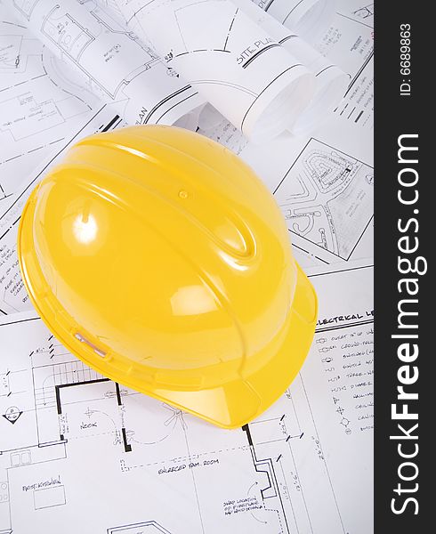 Building plans and yellow hardhat. Building plans and yellow hardhat