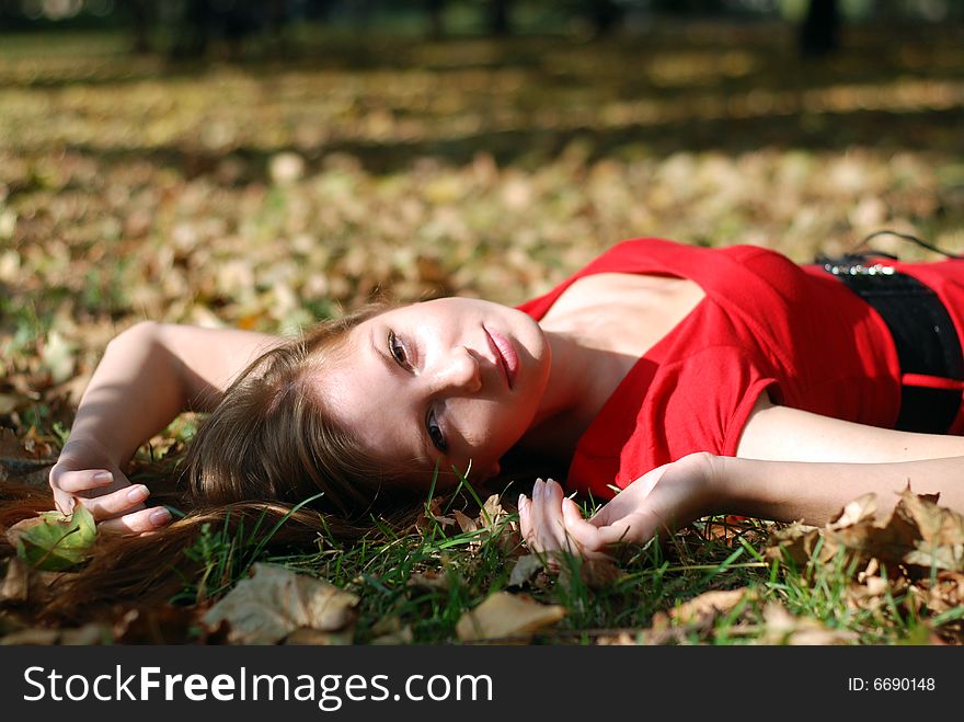 Beautiful young woman lying on the maple leaf. Beautiful young woman lying on the maple leaf