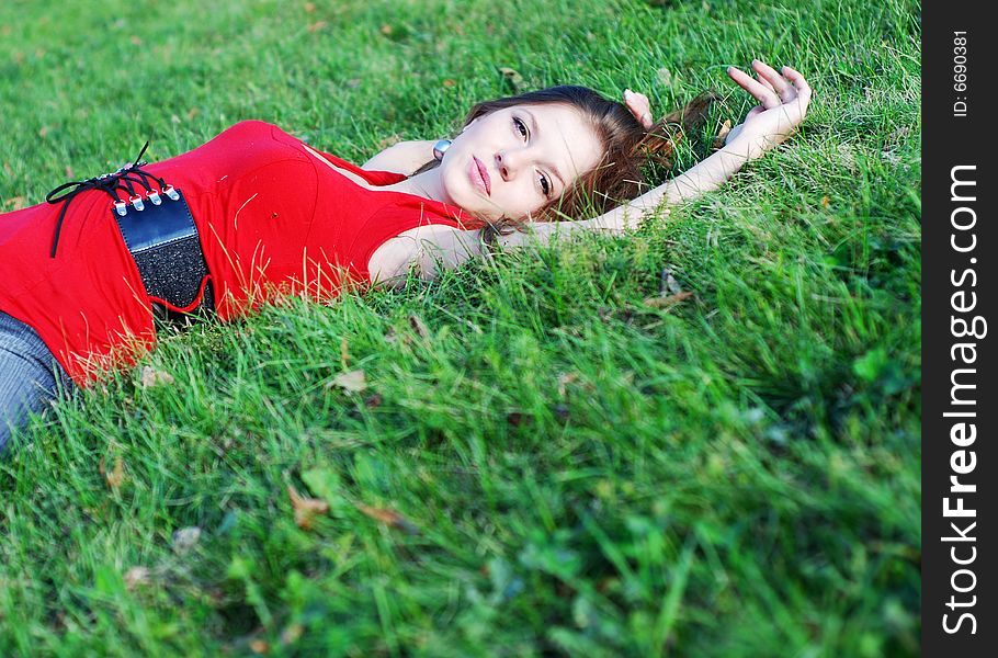 Beautiful young woman in red lying on the green grass. Beautiful young woman in red lying on the green grass