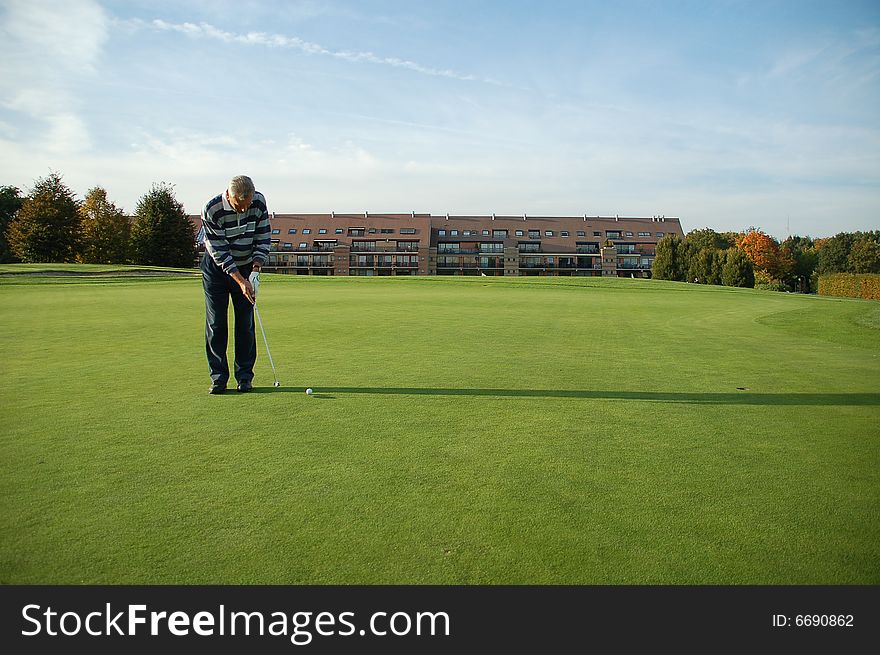 Male golfer putting on the green