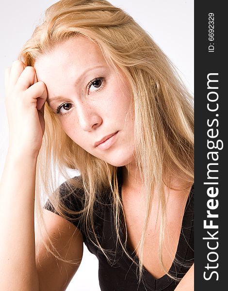 Studio portrait of a young blond girl looking pensive. Studio portrait of a young blond girl looking pensive