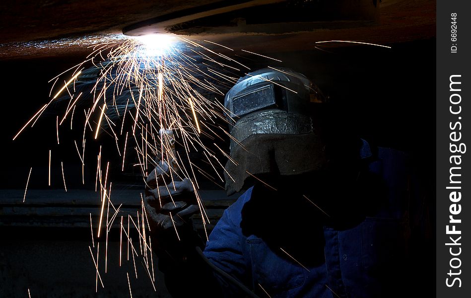 A welder working at shipyard at night. A welder working at shipyard at night