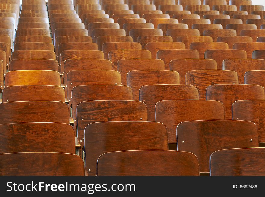 Rows of wood chairs in an old auditorium