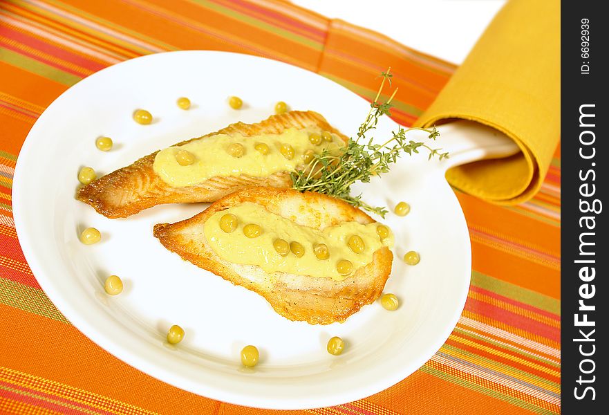 White fish fillet served with a green pea sauce