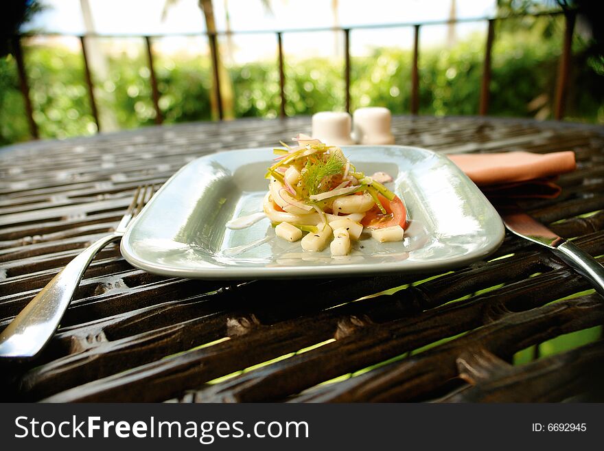 Octopus salad served as a starter in an outdoor restaurant