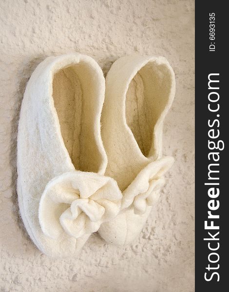 Picture of a pair of felt slippers on a wall