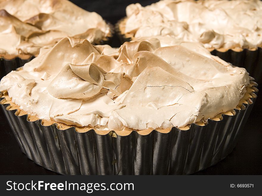 A picture of three lemon meringue pies, frshly baked