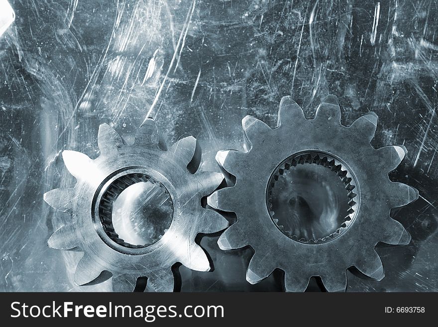 Large gears shot against scratched aluminum background and in a bluish toning idea. Large gears shot against scratched aluminum background and in a bluish toning idea.