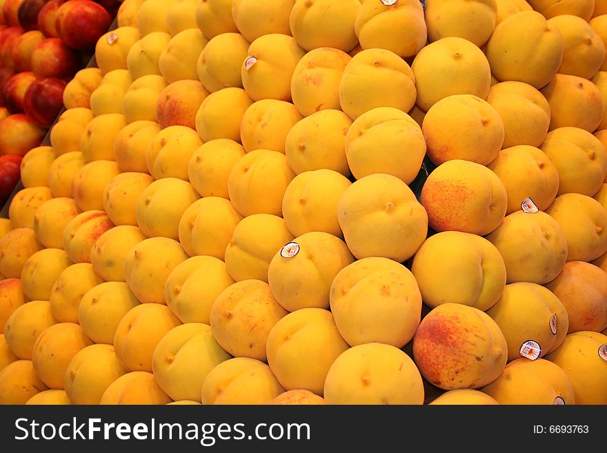 Alot of peaches  on stand in Market in Spain