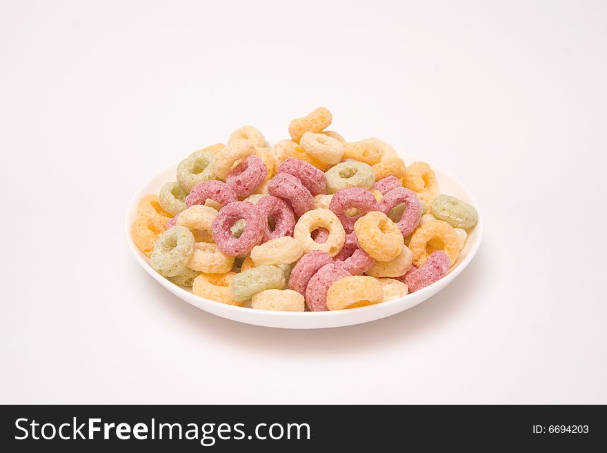 Corn flakes in saucer, isolated on white. Corn flakes in saucer, isolated on white