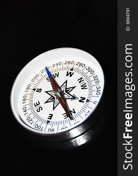 Still life of compass on black background.