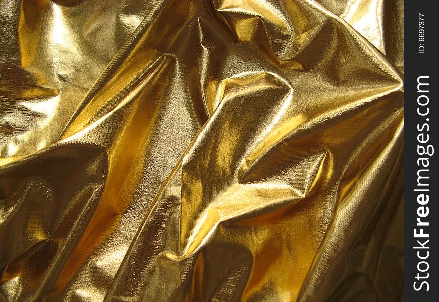 A piece of folded gold metallic fabric. A piece of folded gold metallic fabric