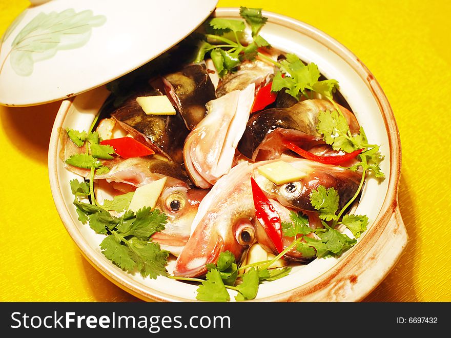 The Chinese dish of braised fresh water fish heads in a pottery casserole. The Chinese dish of braised fresh water fish heads in a pottery casserole.