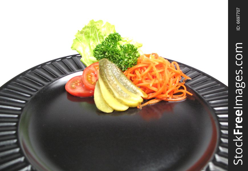 A black plate with some garnish on it. A black plate with some garnish on it