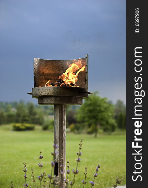 A shiny metal barbecue with burning charcoal. A shiny metal barbecue with burning charcoal