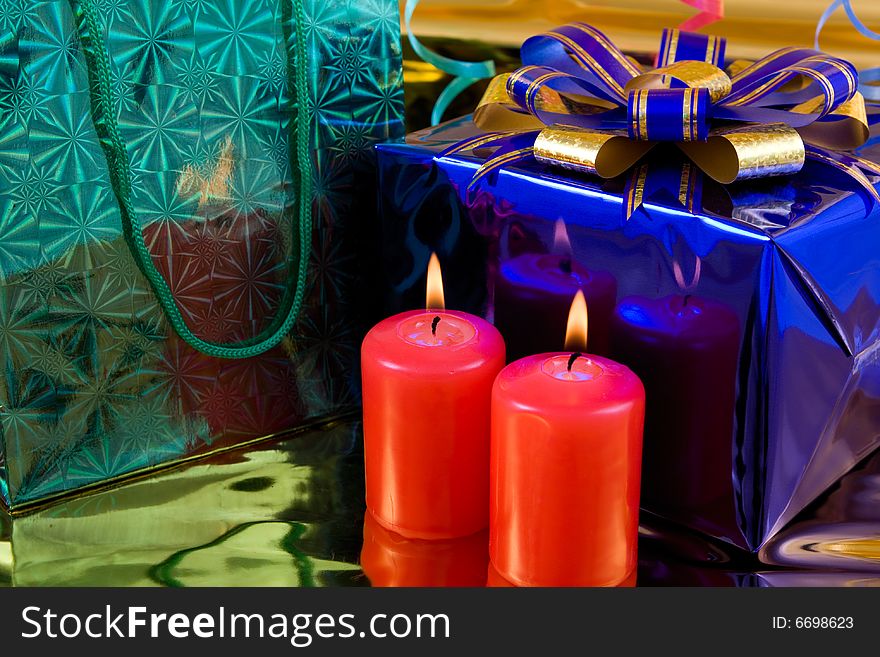 Blue gift box and red burning candles. Blue gift box and red burning candles