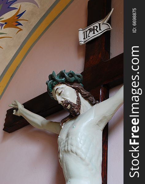 Jesus of Nazaret on cross. Figure in church St. Bartolomeo - village Szyszki, state mazowieckie, Poland. The church of St. Bartolomeo is a historic cathedral constructed in 15th century, reconstructed in 1877-1899 years. It is the church of the Roman Catholic Diocese PÅ‚ock. Jesus of Nazaret on cross. Figure in church St. Bartolomeo - village Szyszki, state mazowieckie, Poland. The church of St. Bartolomeo is a historic cathedral constructed in 15th century, reconstructed in 1877-1899 years. It is the church of the Roman Catholic Diocese PÅ‚ock.