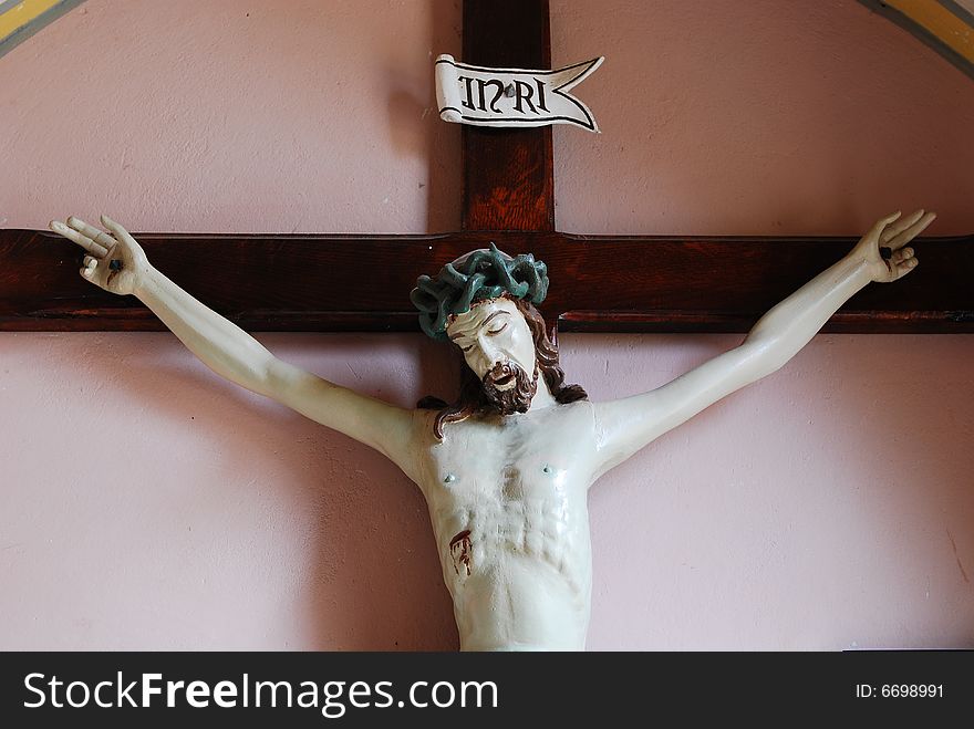 Jesus of Nazaret on cross. Figure  in church St. Bartolomeo - village Szyszki, state mazowieckie, Poland. The church of St. Bartolomeo is a historic cathedral constructed in 15th century, reconstructed in 1877-1899 years. It is the church of the Roman Catholic Diocese Płock. Jesus of Nazaret on cross. Figure  in church St. Bartolomeo - village Szyszki, state mazowieckie, Poland. The church of St. Bartolomeo is a historic cathedral constructed in 15th century, reconstructed in 1877-1899 years. It is the church of the Roman Catholic Diocese Płock.