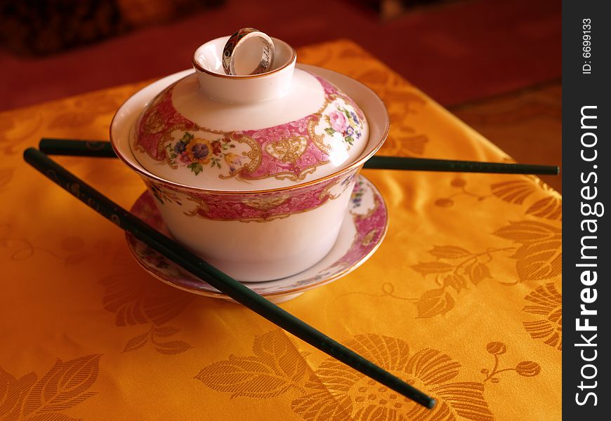 Chinese cup with chop sticks on a table. Chinese cup with chop sticks on a table
