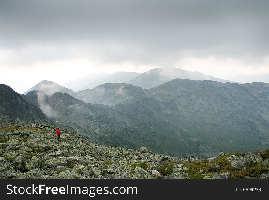 A person lost in the middle of foggy mountains. A person lost in the middle of foggy mountains