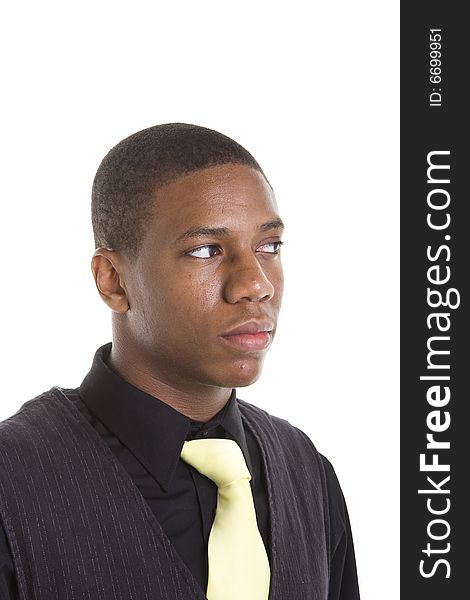 A young black man in a black shirt and sweater on white background wearing a yellow tie, looking to the right. A young black man in a black shirt and sweater on white background wearing a yellow tie, looking to the right