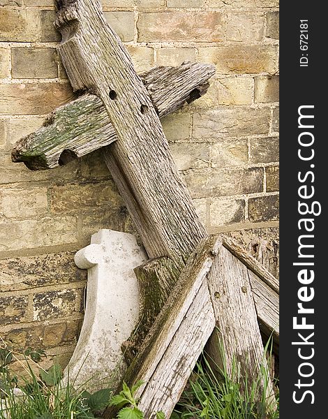 A rotten wooden cross head stone in pieces. A rotten wooden cross head stone in pieces.