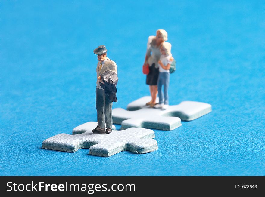 Two plastic figures standing on two puzzle pieces. Two plastic figures standing on two puzzle pieces