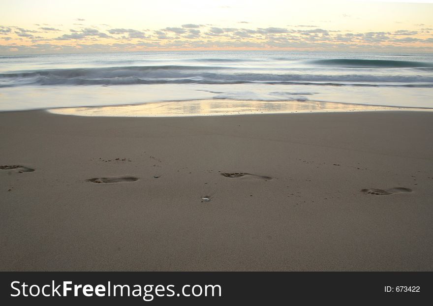 Solitary footprints on the beach at sunrise. Solitary footprints on the beach at sunrise