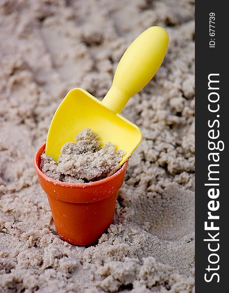 Yellow Small Shovel with Bucket in Sand. Yellow Small Shovel with Bucket in Sand