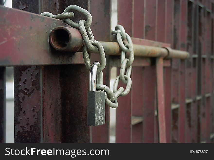Exterior of padlock and chain on metal gate. Exterior of padlock and chain on metal gate.