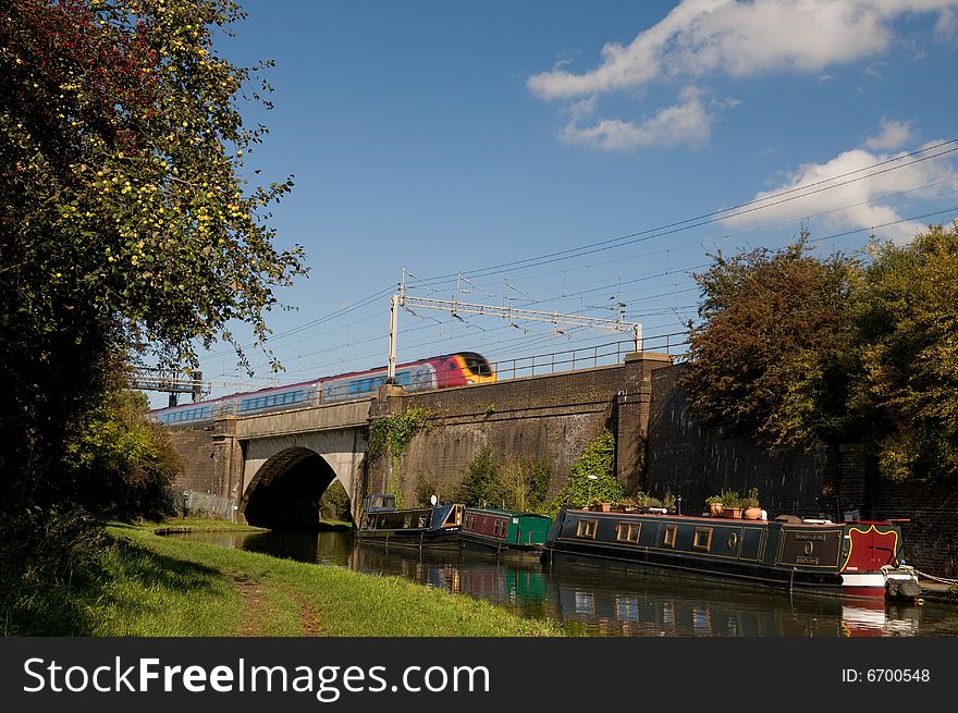 An intercity train crosses a bridge over a canal barge. An intercity train crosses a bridge over a canal barge