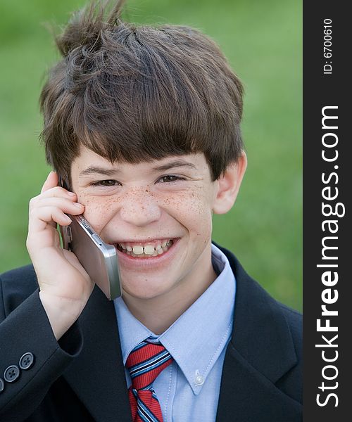 Little Boy Dressed up Talking on Cell Phone on a Windy Day. Little Boy Dressed up Talking on Cell Phone on a Windy Day