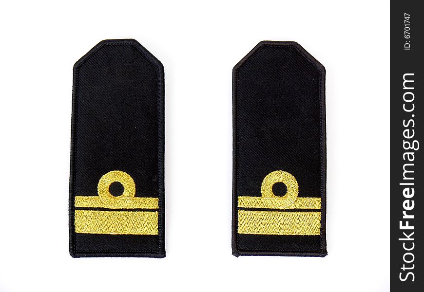 Close up of two black navy epaulets with gold trim.