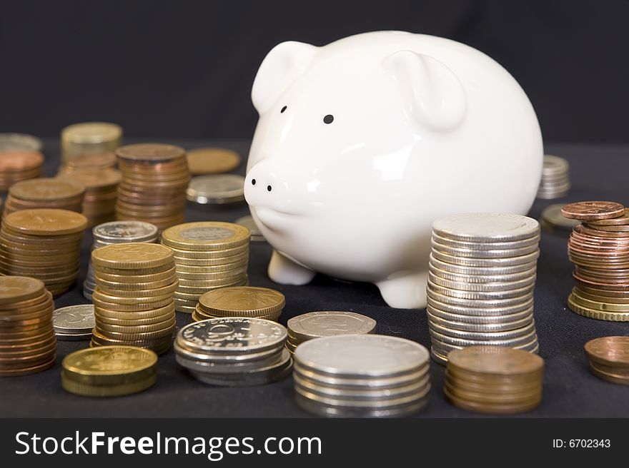 Piggy bank with various international currencies on a black background. Piggy bank with various international currencies on a black background.