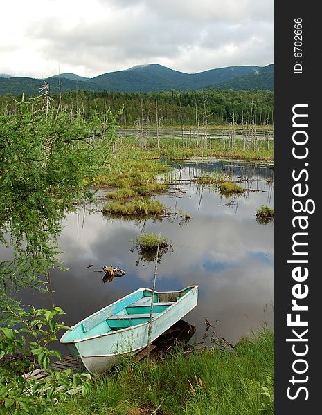 Photo of abandoned old boat in the middle of marsh, Canada. Photo of abandoned old boat in the middle of marsh, Canada