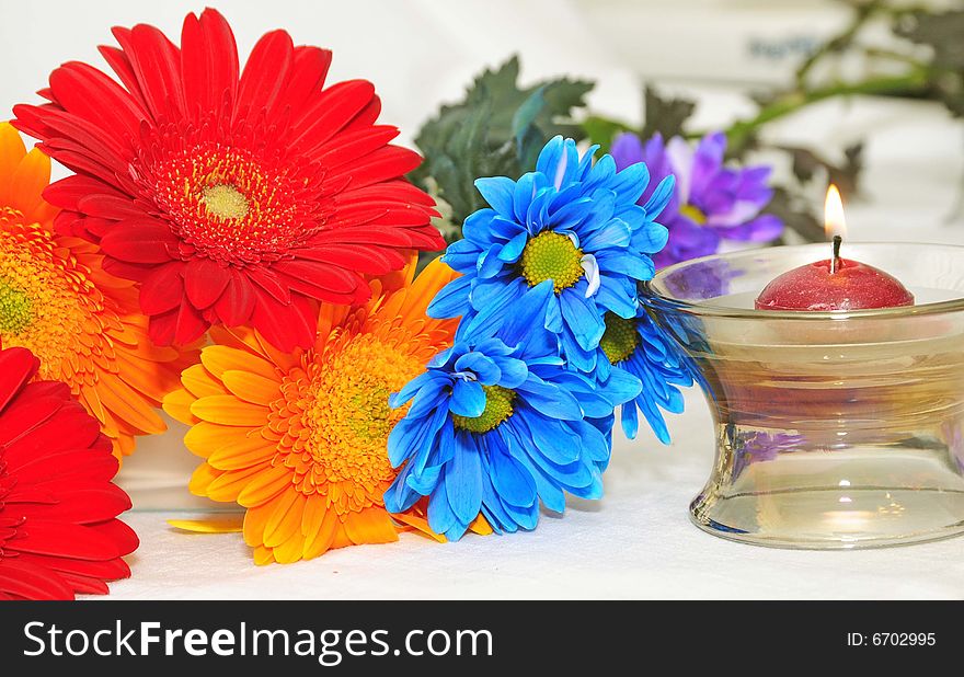 A colorful bunch of flowers and candle. A colorful bunch of flowers and candle