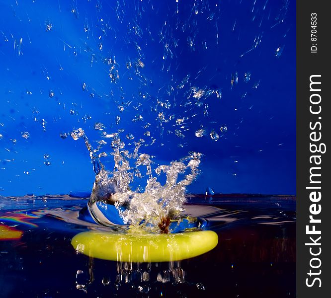 Blue splash background with sinking apple