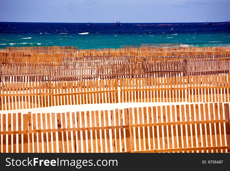 Wooden fence on deserted beach dunes in Tarifa, Spain