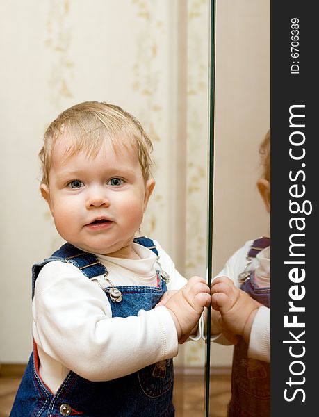 Small smiling baby playing with mirror at home